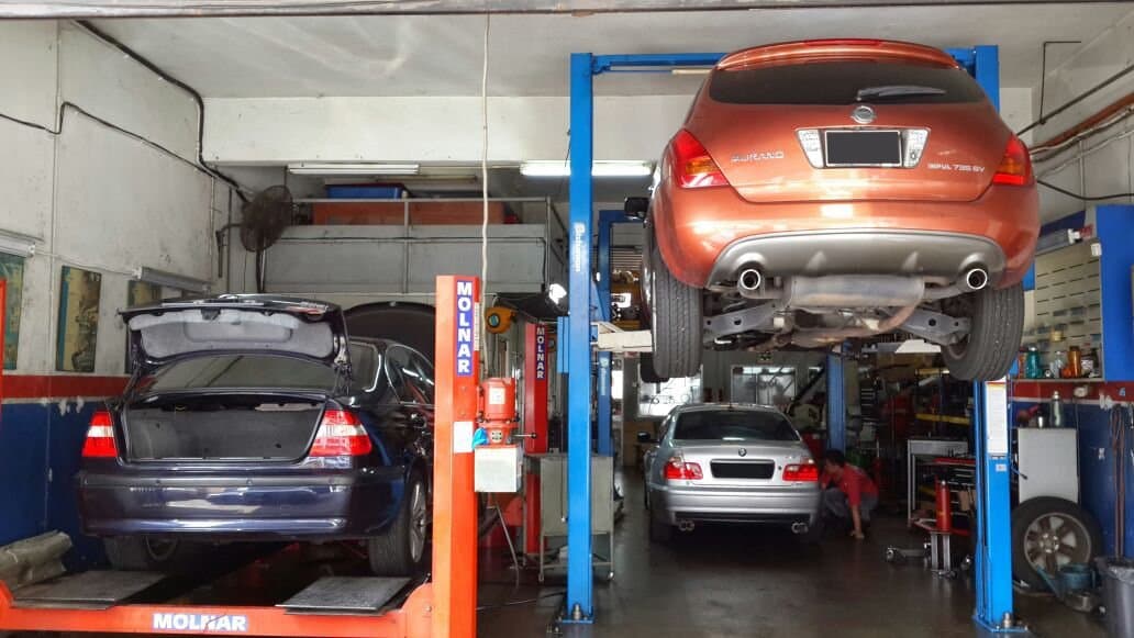 The M-Scope workshop floor, cars raised on lifts and a technician working