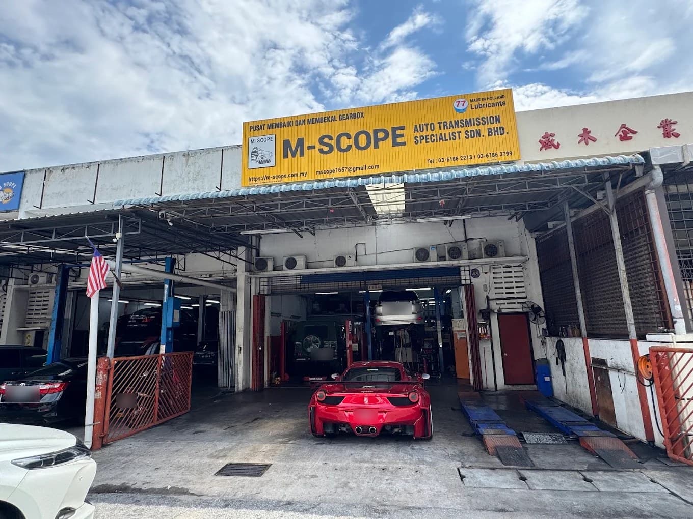 The M-Scope Auto Transmission Specialist shopfront in Batu Caves, cars in the service bays under the yellow sign